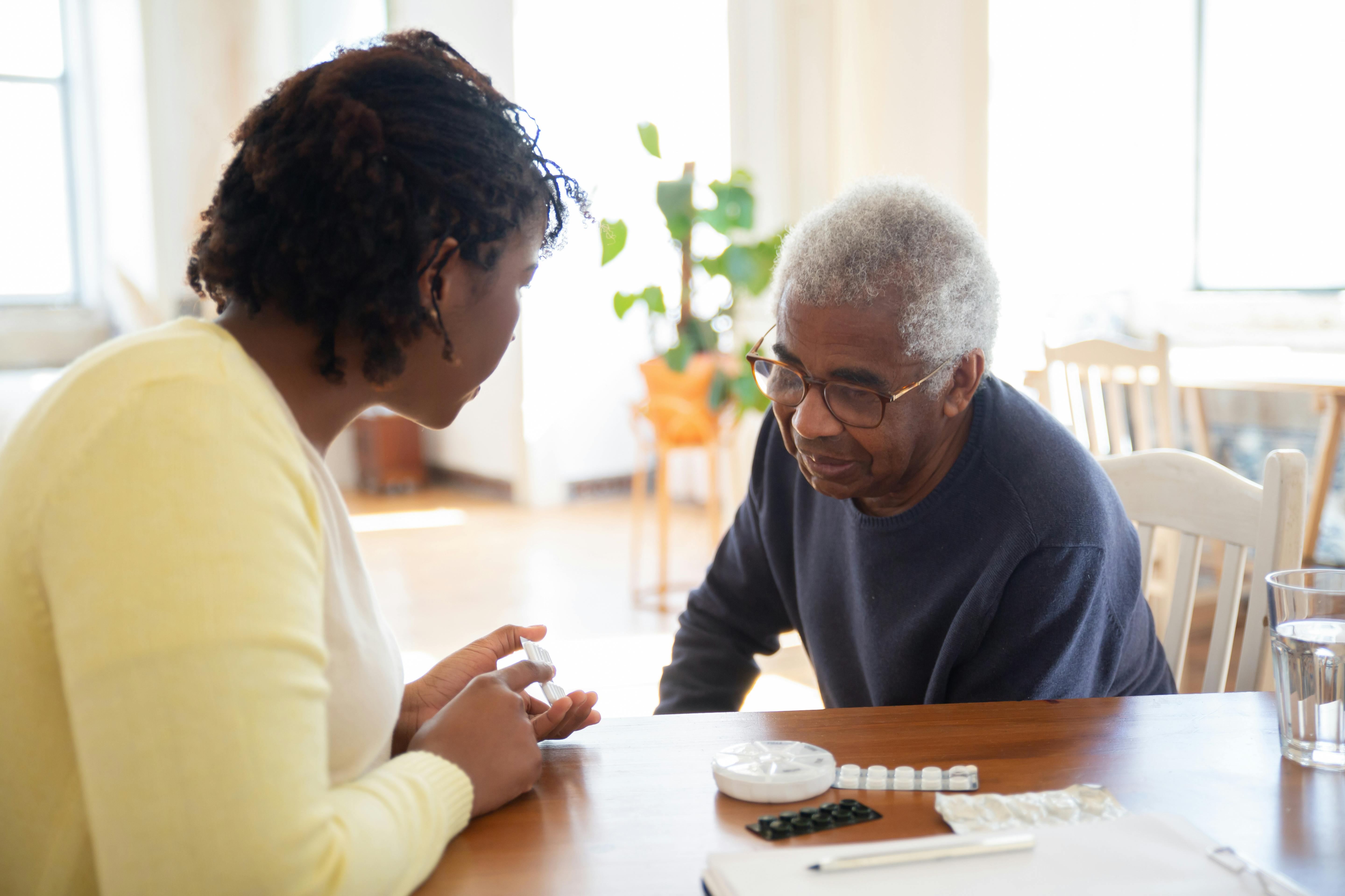 Home health nurse discussing medication with an elderly patient in Philadelphia